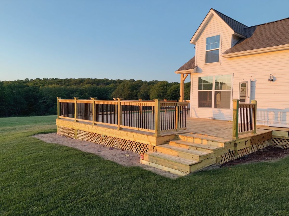 A newly built wood deck on the back of a white house